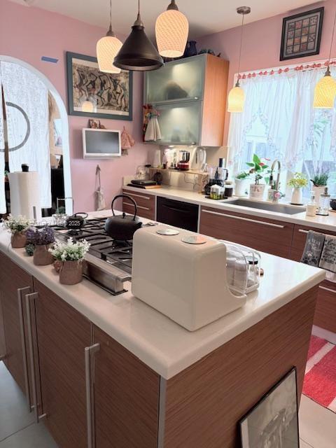 1643 Nethia Dr, Miami, FL 33133 - kitchen featuring light countertops, black dishwasher, arched walkways, a sink, and hanging light fixtures