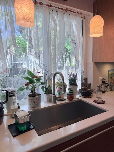 1643 Nethia Dr, Miami, FL 33133 - kitchen view of a sink, light countertops, and hanging light fixtures