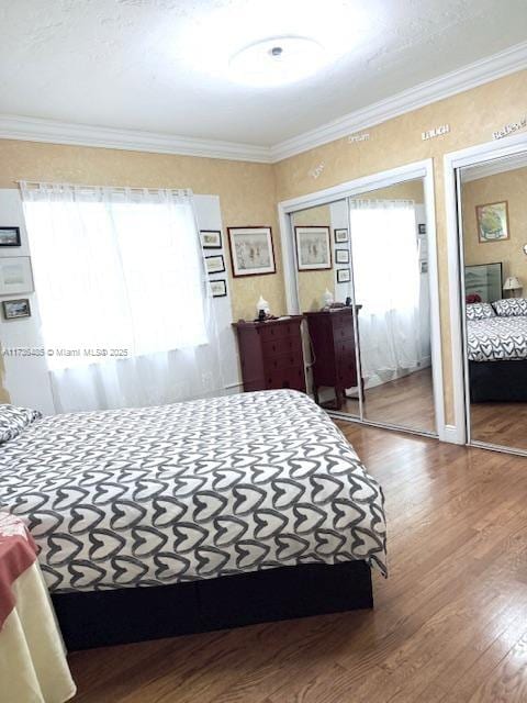 bedroom with wood finished floors and ornamental molding