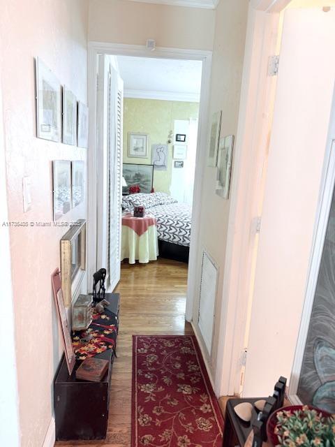 1643 Nethia Dr, Miami, FL 33133 - hall featuring wood finished floors and crown molding