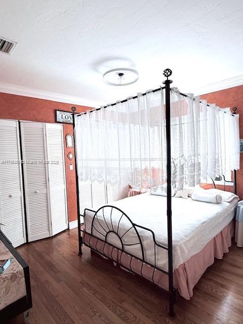1643 Nethia Dr, Miami, FL 33133 - bedroom with a textured ceiling, visible vents, ornamental molding, and wood finished floors