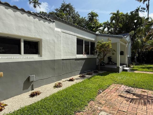 1643 Nethia Dr, Miami, FL 33133 - view of side of property featuring a yard and stucco siding