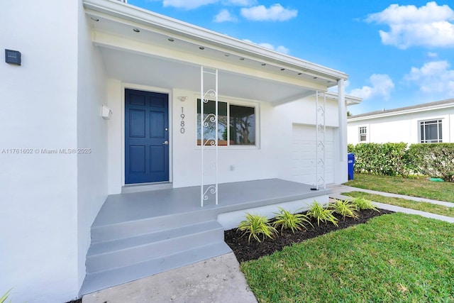 property entrance with stucco siding and a garage