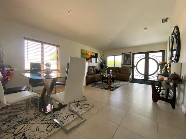 tiled dining area featuring a wealth of natural light, visible vents, french doors, and vaulted ceiling