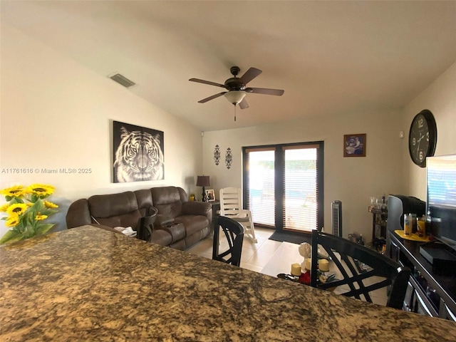 interior space with visible vents, ceiling fan, and vaulted ceiling