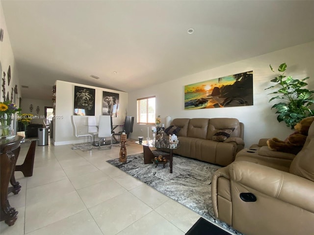 living area featuring light tile patterned floors, visible vents, and baseboards