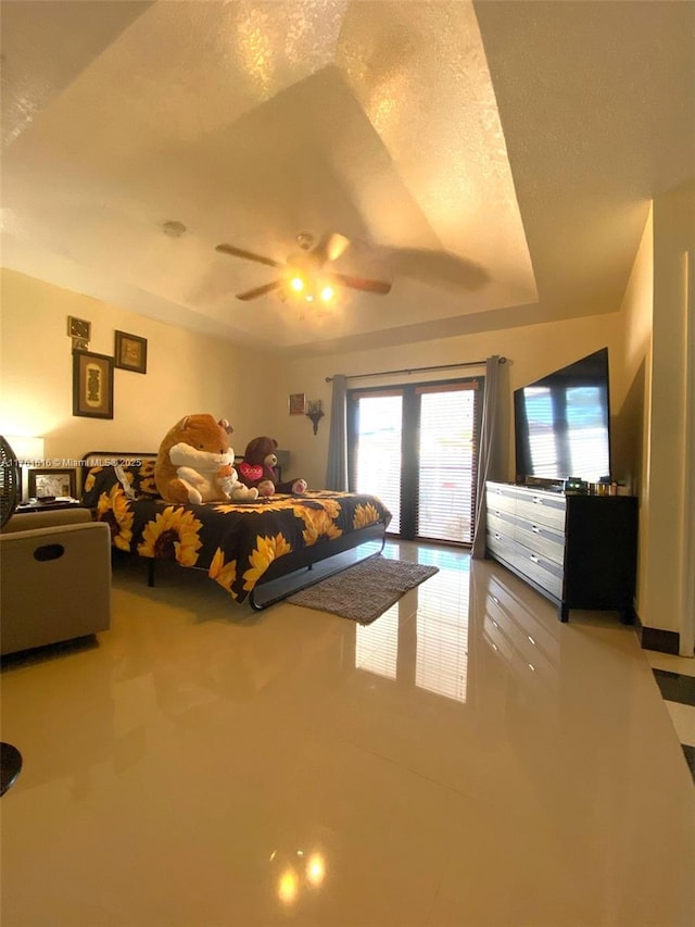 unfurnished bedroom featuring a textured ceiling, a raised ceiling, ceiling fan, and access to outside