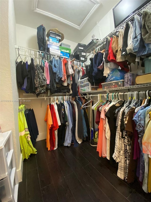 spacious closet with attic access and wood finished floors