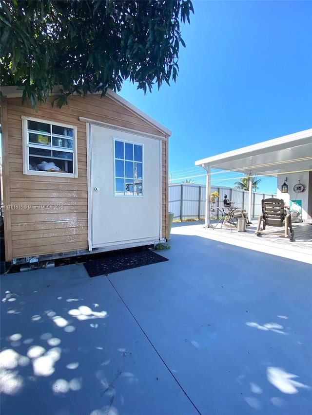 view of outbuilding featuring fence