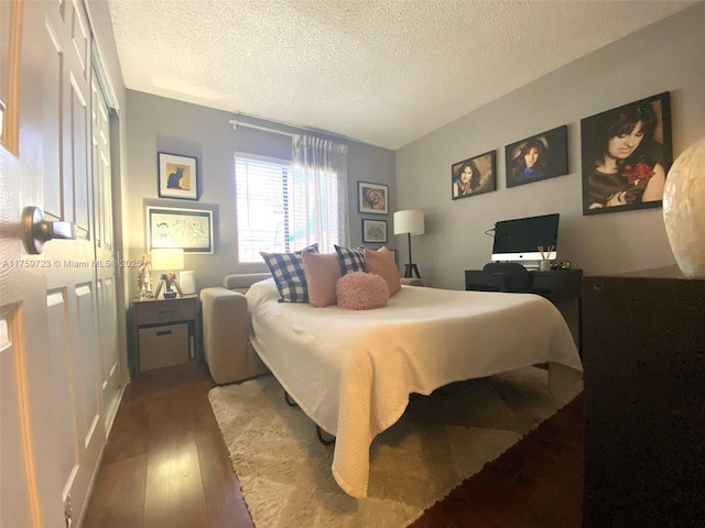 bedroom featuring wood finished floors and a textured ceiling