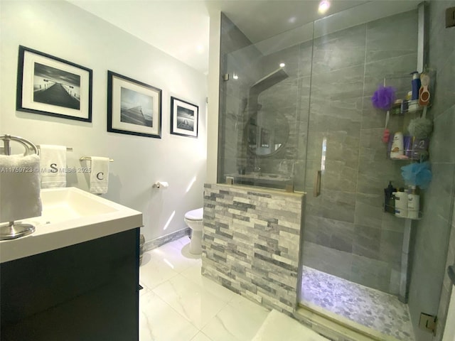 full bathroom featuring toilet, marble finish floor, a shower stall, baseboards, and vanity