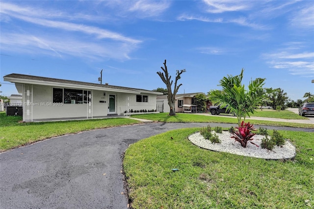 ranch-style home with aphalt driveway and a front yard