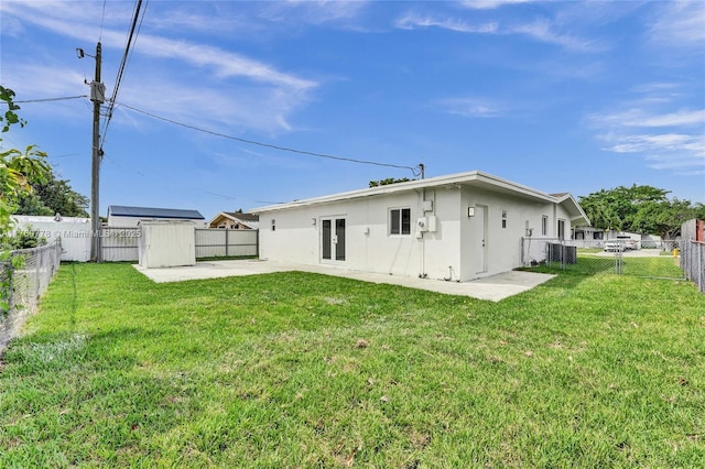 back of house with a patio area, a yard, a fenced backyard, and stucco siding