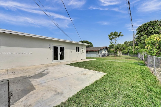 view of yard with a patio, french doors, and a fenced backyard