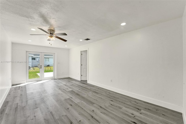 spare room with recessed lighting, wood finished floors, baseboards, and french doors