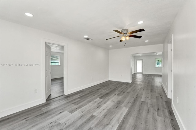 spare room featuring recessed lighting, wood finished floors, and baseboards