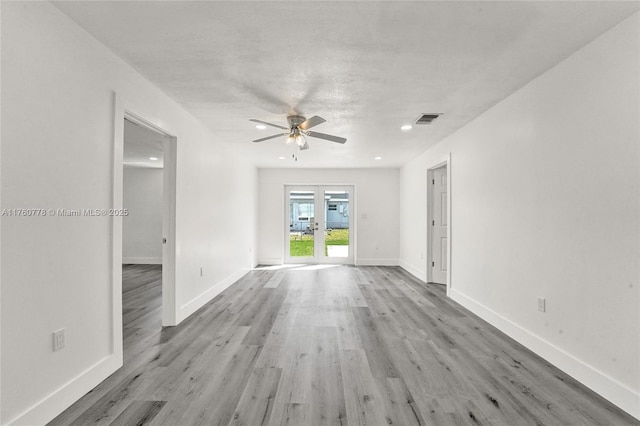 empty room with visible vents, french doors, light wood finished floors, baseboards, and ceiling fan