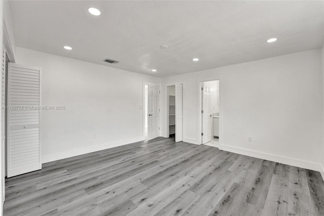 unfurnished room featuring recessed lighting, visible vents, baseboards, and wood finished floors