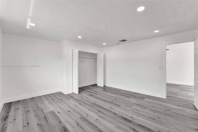 spare room featuring recessed lighting, visible vents, baseboards, and wood finished floors