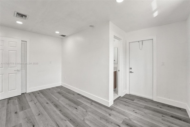 unfurnished room featuring visible vents, baseboards, and wood finished floors