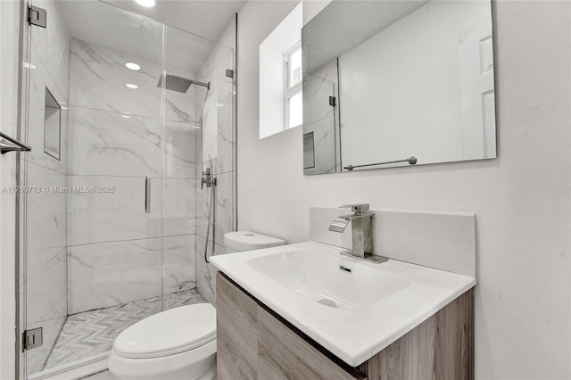 bathroom with a marble finish shower, toilet, and vanity