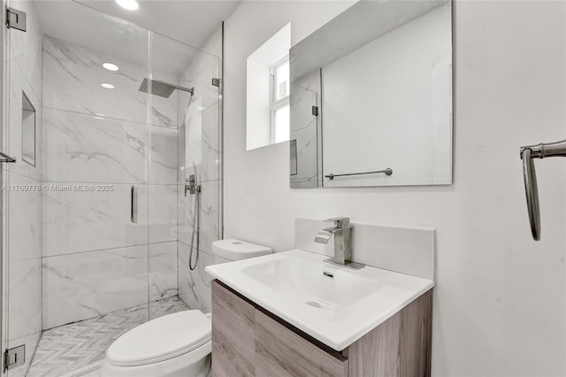 full bath with vanity, toilet, and a marble finish shower