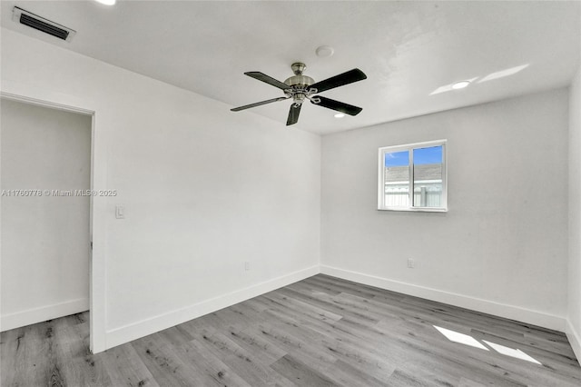 unfurnished bedroom with visible vents, baseboards, wood finished floors, and a ceiling fan