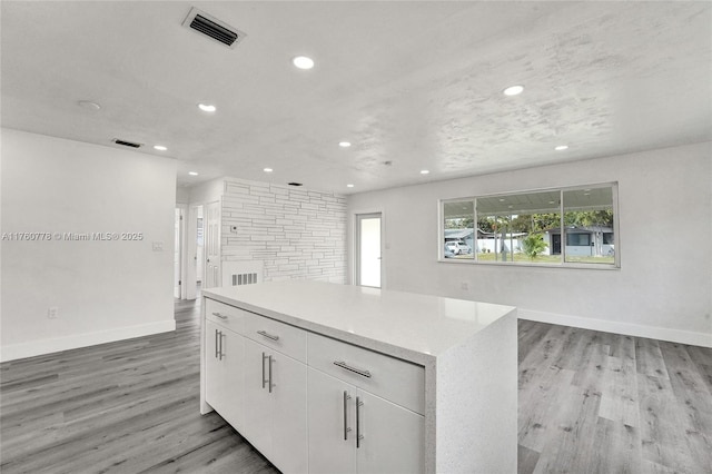 kitchen with recessed lighting, visible vents, light wood finished floors, and a center island