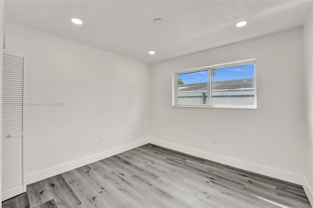 empty room with recessed lighting, baseboards, and wood finished floors