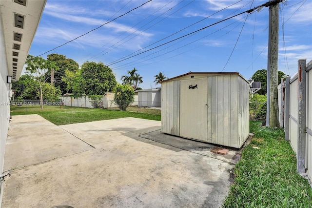 view of patio with an outdoor structure, a fenced backyard, and a shed