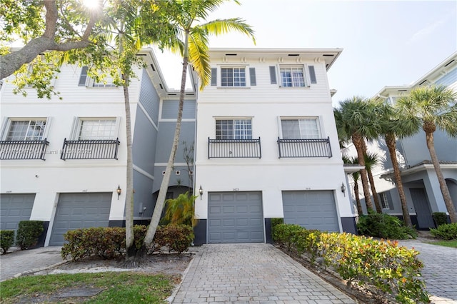 view of property featuring decorative driveway and an attached garage