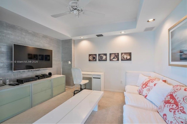 living room featuring recessed lighting, visible vents, a raised ceiling, and light colored carpet