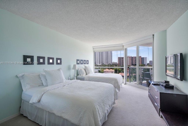 carpeted bedroom featuring a wall of windows and a textured ceiling