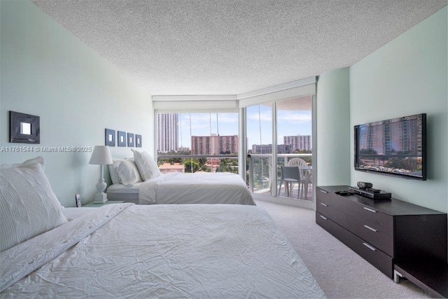 carpeted bedroom featuring expansive windows, a textured ceiling, and access to exterior