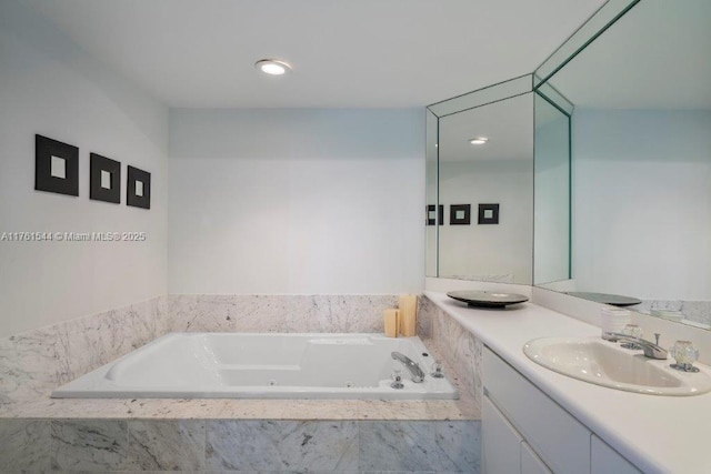 bathroom with a whirlpool tub and vanity