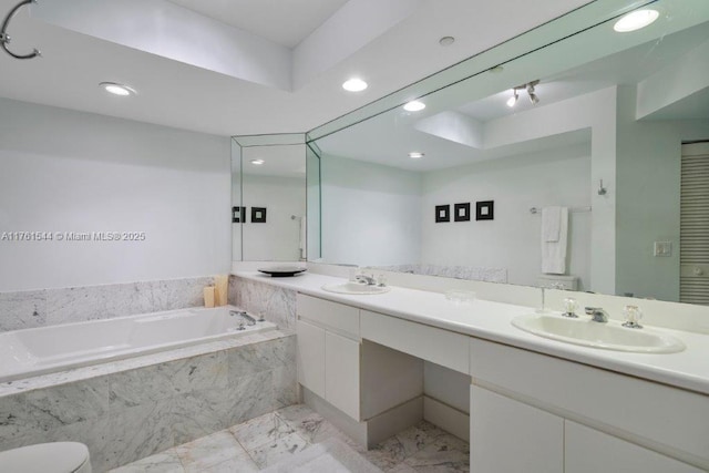 bathroom with double vanity, a bath, marble finish floor, and a sink