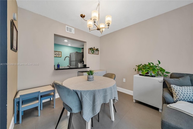 dining room with baseboards, visible vents, and a chandelier