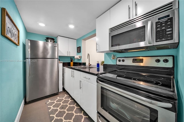 kitchen featuring a sink, dark countertops, white cabinetry, and stainless steel appliances