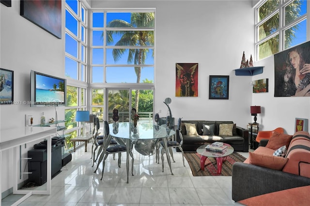 living area with tile patterned floors and a towering ceiling