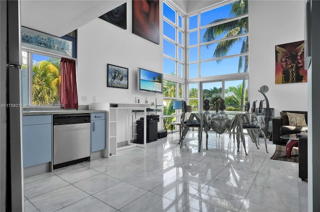 interior space with stainless steel dishwasher and a towering ceiling