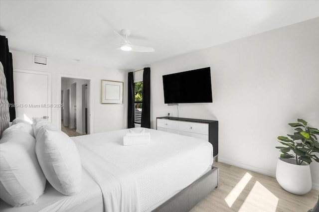 bedroom featuring light wood-type flooring, baseboards, visible vents, and a ceiling fan