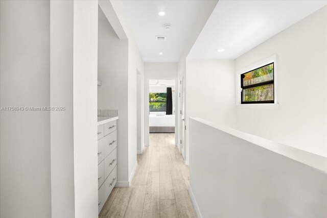 hall with light wood-style flooring, recessed lighting, baseboards, and visible vents