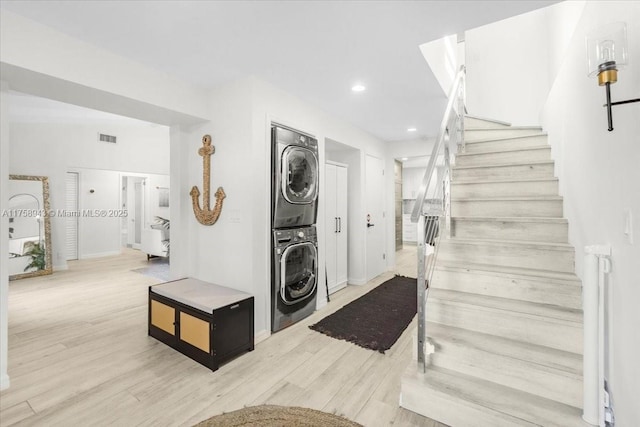 stairway featuring recessed lighting, wood finished floors, visible vents, and stacked washing maching and dryer