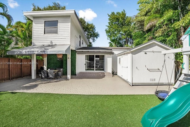 back of house with a yard, a playground, a patio, and fence