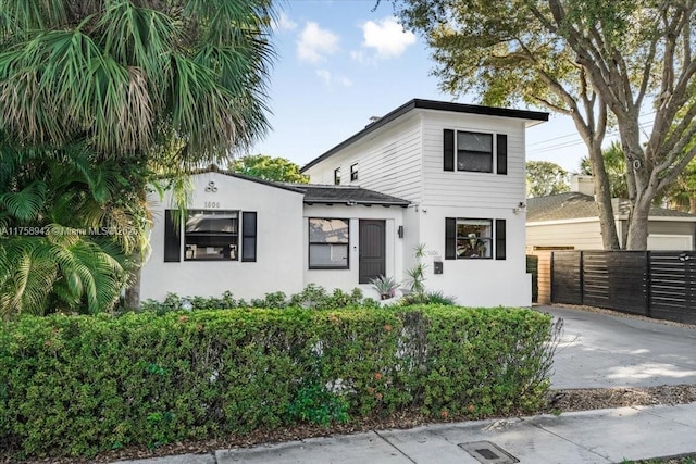 view of front of home featuring stucco siding and fence