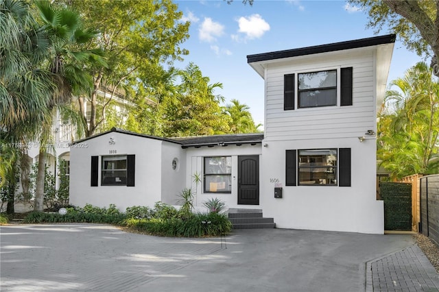 view of front facade with stucco siding and fence