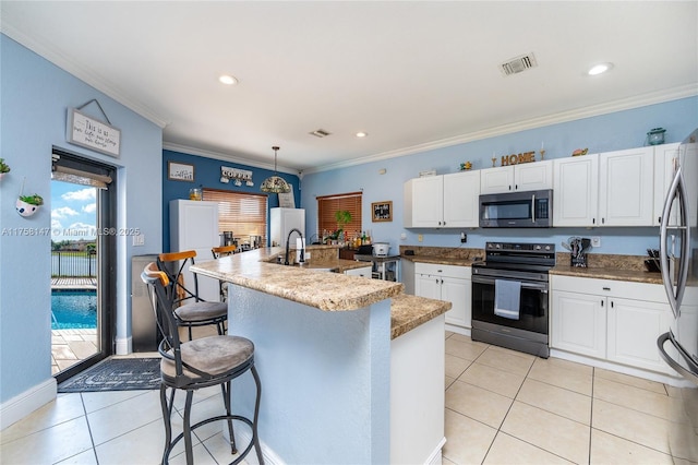 kitchen featuring visible vents, ornamental molding, light tile patterned floors, appliances with stainless steel finishes, and white cabinets