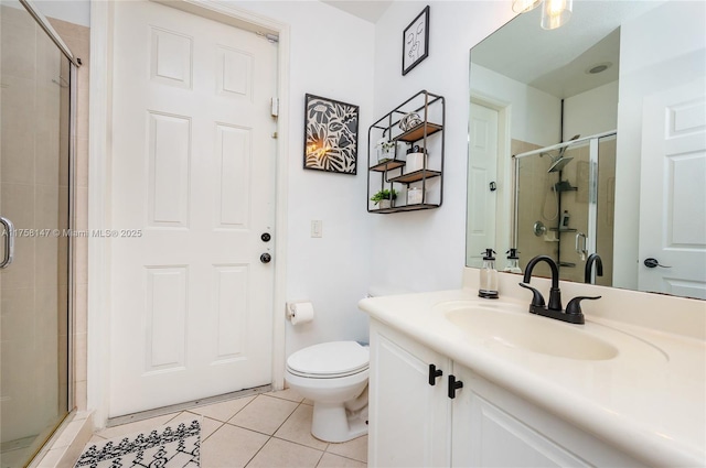 bathroom featuring toilet, a stall shower, vanity, and tile patterned flooring