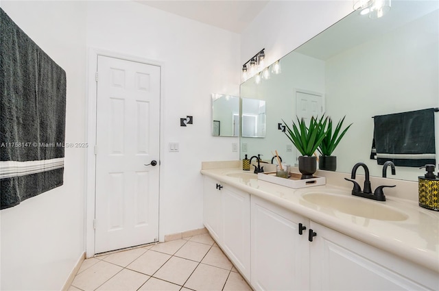 bathroom with tile patterned floors, double vanity, baseboards, and a sink