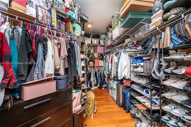 walk in closet with wood finished floors